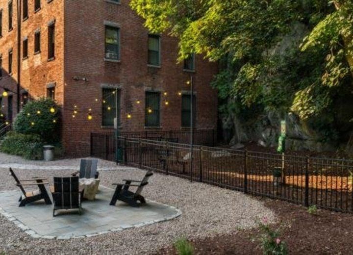 a yard with two chairs and a brick building